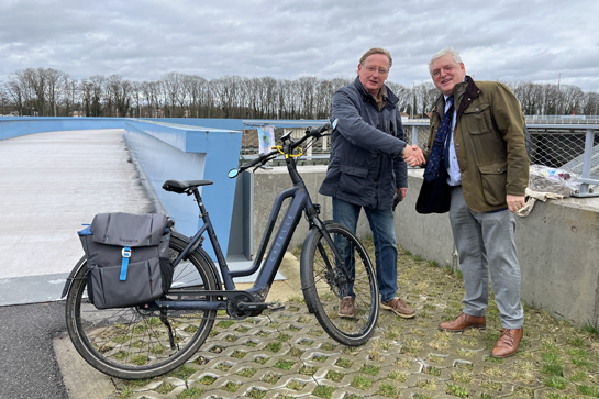 Gedeputeerde Bert Lambrechts (rechts) feliciteert Hendrik Claes, de miljoenste fietser op de Langeman. 